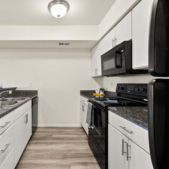 a kitchen with black appliances and white cabinets.