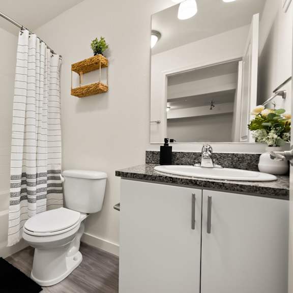 a white toilet sits in a bathroom next to a white bathtub.
