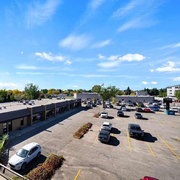 a parking lot with several cars and a building in the background.