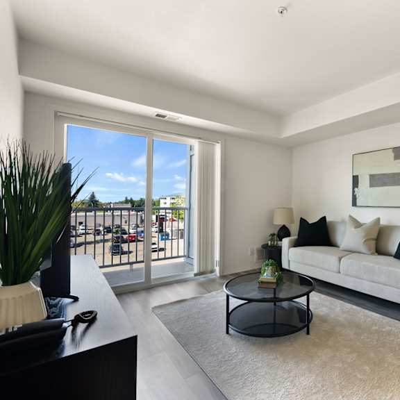 a living room with a couch, coffee table, and sliding glass doors.