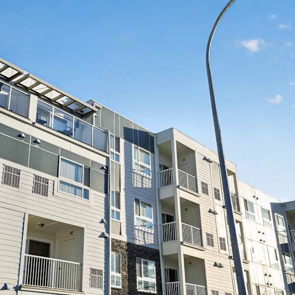 a modern apartment building with balconies and large windows.