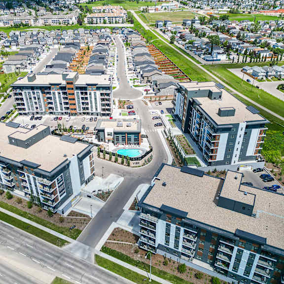 a bird's eye view of a residential area with apartment buildings and a pool.