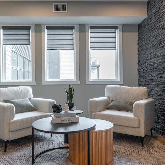 a living room with a stone wall and a round coffee table.at vista apartments at edgemont, alberta