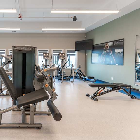 a gym with a variety of equipment including a leg press machine.at vista apartments at edgemont, edmonton, ab
