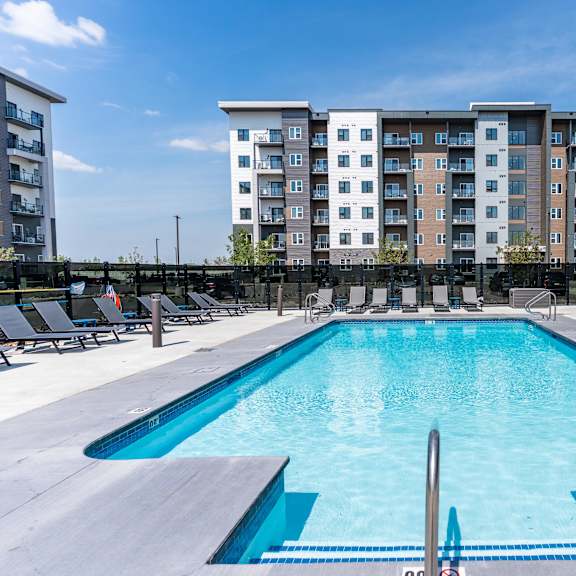 a large swimming pool in front of apartment buildings.