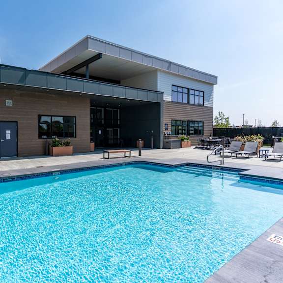 outdoor pool with modern clubhouse building at mac and mullen apartments, edmonton, ab