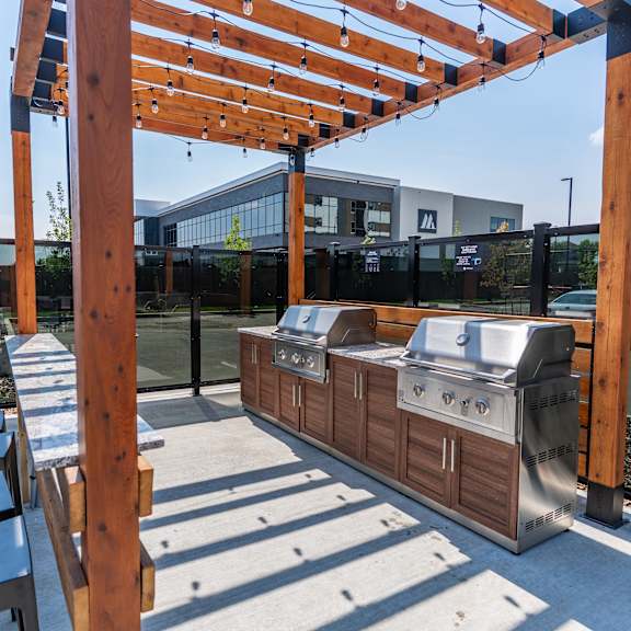 outdoor grilling area with barbecue stations at mac and mullen apartments, edmonton, t6r 0s7