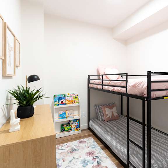 a small room with a bunk bed and a desk.at podium apartments, calgary, ab