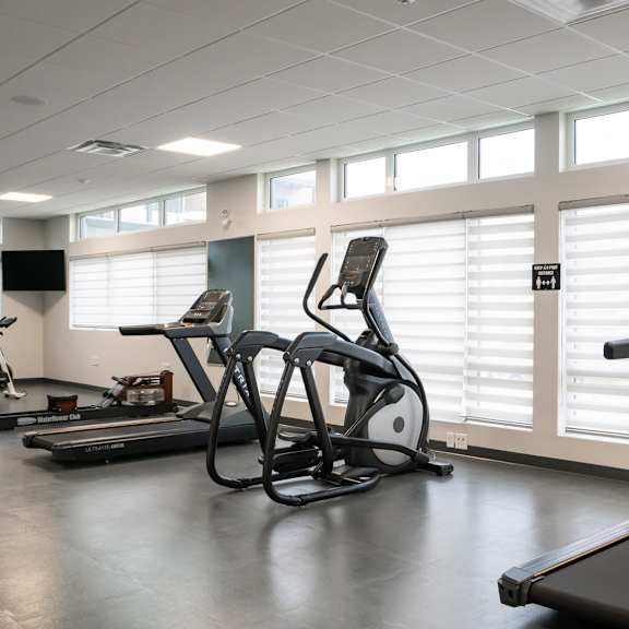 a gym with treadmills and exercise bikes.