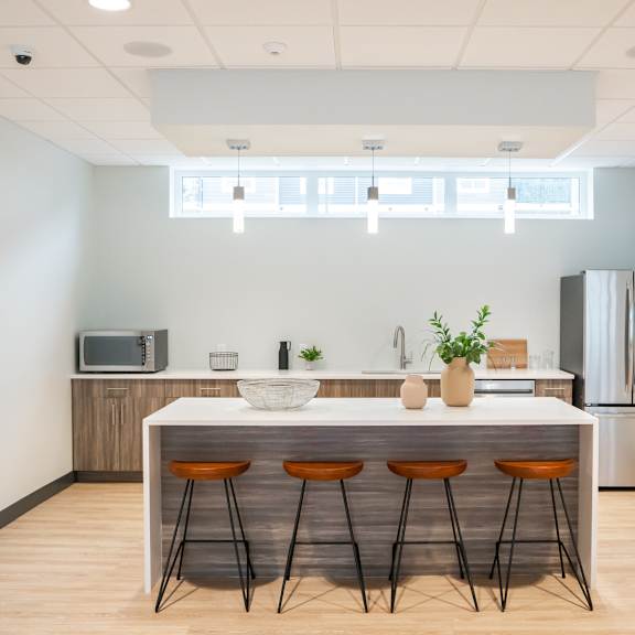 a kitchen with a white counter and bar stools.