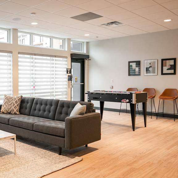 a living room with two couches, a coffee table, and a dining table.