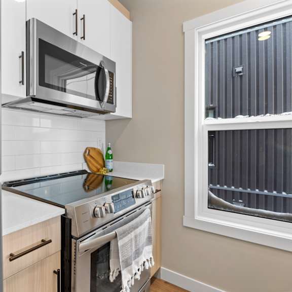 a modern kitchen with a stainless steel refrigerator, microwave, and oven.