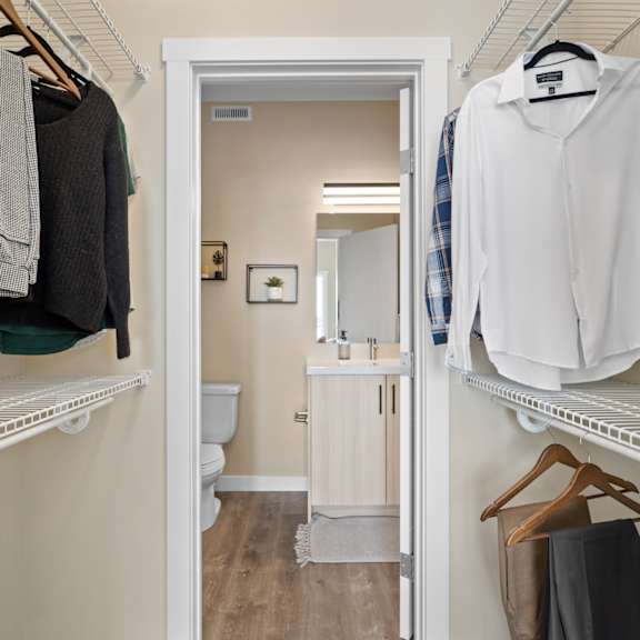 a white shirt hanging on a white shelf in a white closet.