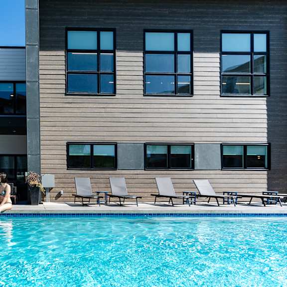 a swimming pool with lounge area at podium apartments, alberta