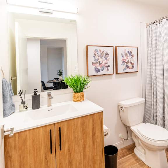 a bathroom with a toilet, sink, and shower.at the artisan at rangeview, calgary, alberta