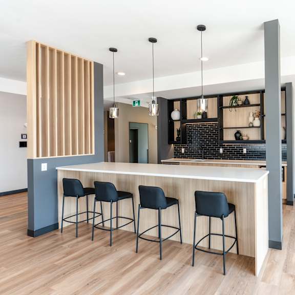 a bar area with a wooden counter and stools.