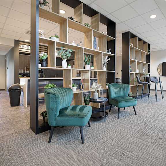 a room with a green chair and a wooden shelf.