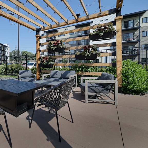 a patio with a table and chairs under a pergola.