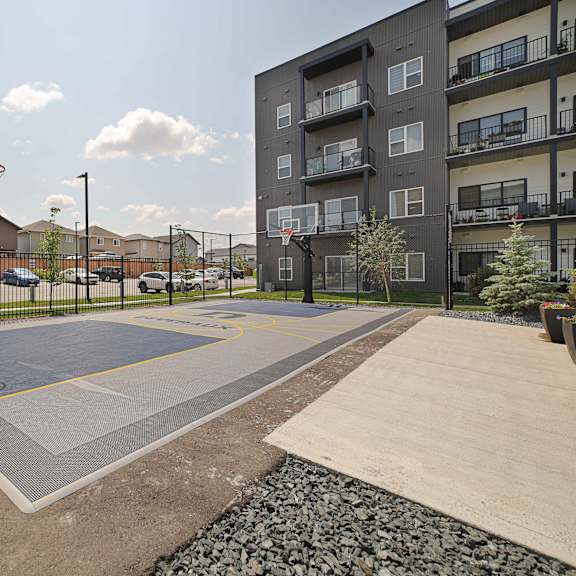a basketball court is located in a courtyard surrounded by apartment buildings.