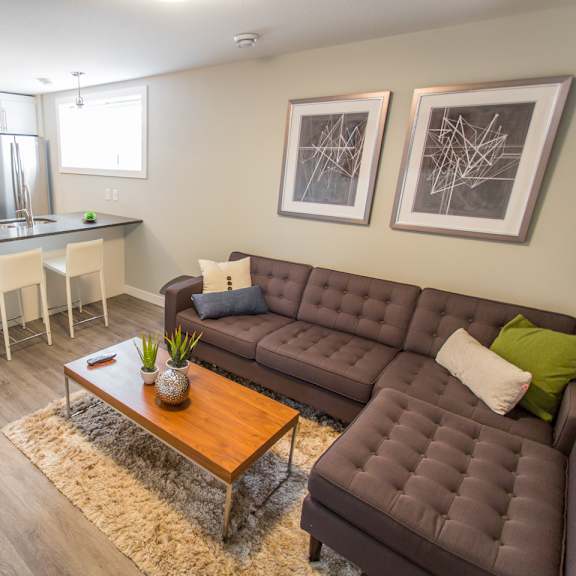 a brown couch with a vase on a coffee table in a kitchen.