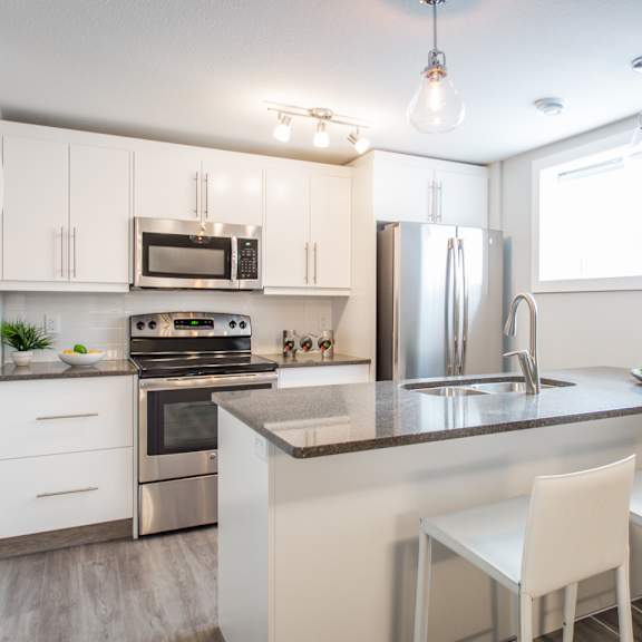a kitchen with white cabinets and a granite countertop.