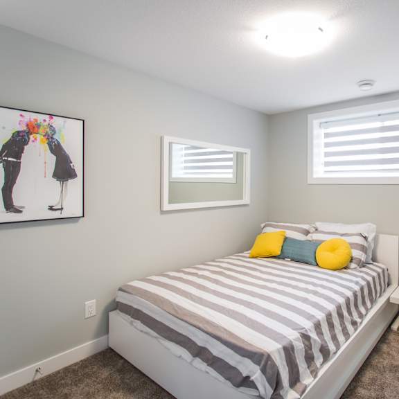 a bedroom with a bed, nightstand, and a painting on the wall.