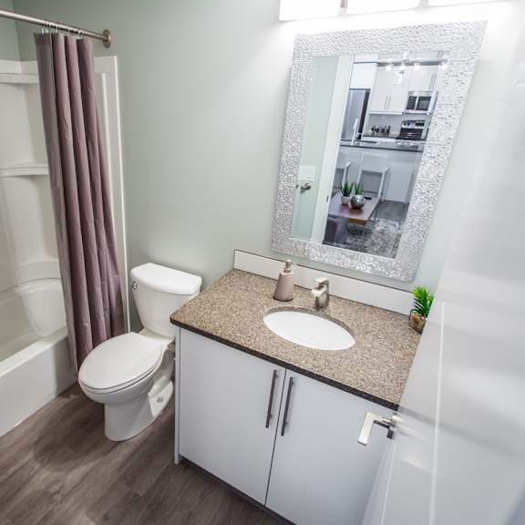 a bathroom with a toilet, sink, and shower.