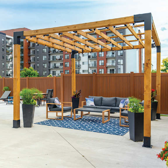 a wooden pergola is over a seating area.at latitude 49 townhomes, manitoba