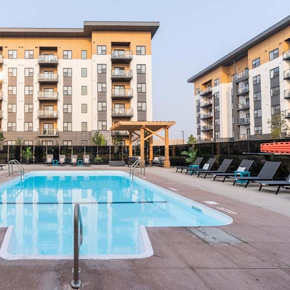 a large swimming pool in front of apartment buildings.