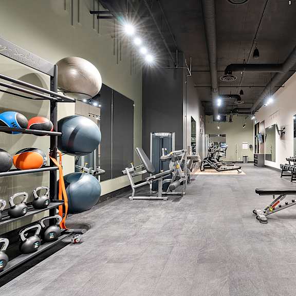 a gym with a variety of equipment including weights and a bench press.at raymond block, edmonton alberta t6e 3r7