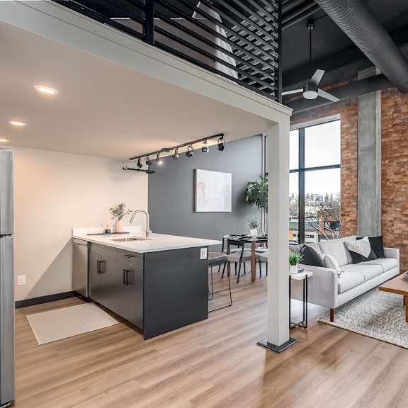 a modern kitchen with a refrigerator, sink, and a dining table with chairs.at raymond block, edmonton