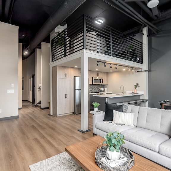 a modern living room with a grey sofa and a wooden coffee table.at raymond block, edmonton, ab