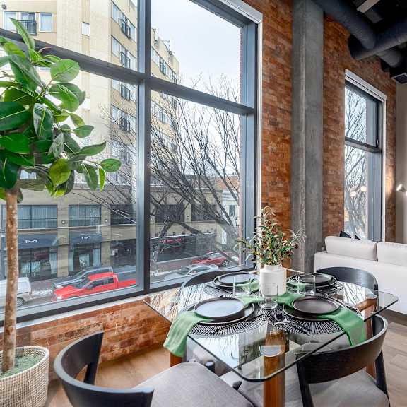 a modern living room with a glass table and a white couch.at raymond block, alberta
