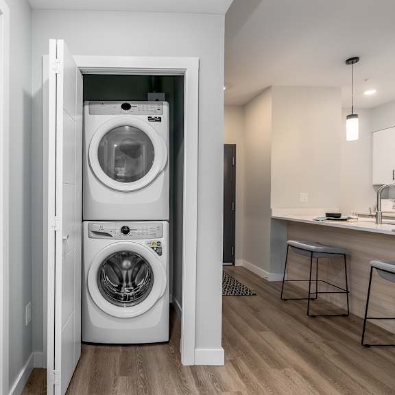 a white washer and dryer are in a small laundry room.
