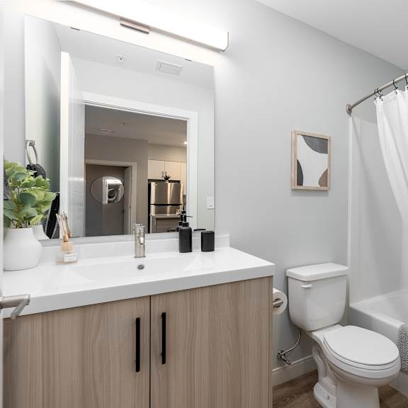 a white bathroom with a toilet, sink, and shower.