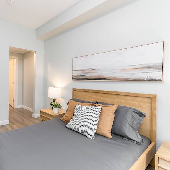a bedroom with a large bed and a painting on the wall.