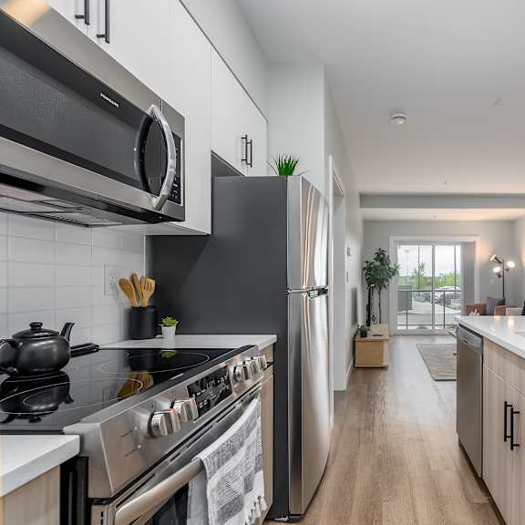 a modern kitchen with stainless steel appliances and wooden cabinets.