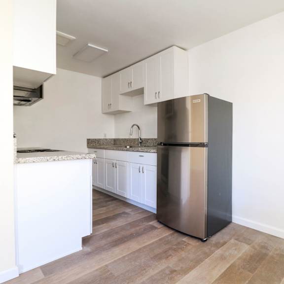 a kitchen with a stainless steel refrigerator and white cabinets.