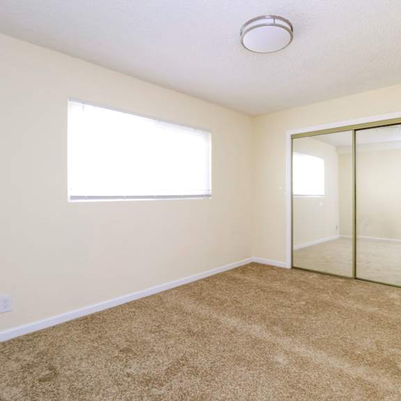 a room with a carpeted floor and a sliding glass door.