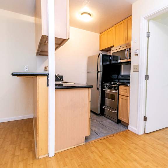 a kitchen with black appliances and wooden cabinets.