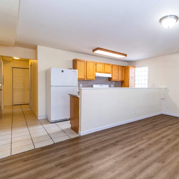a kitchen with wooden floors and white walls.