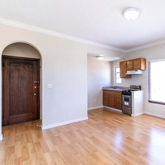 a room with a wooden floor and a brown door.