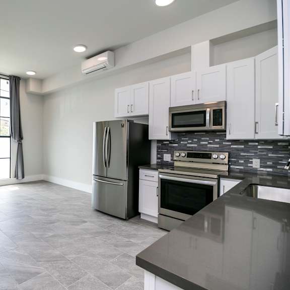 a kitchen with a refrigerator, oven, and microwave.