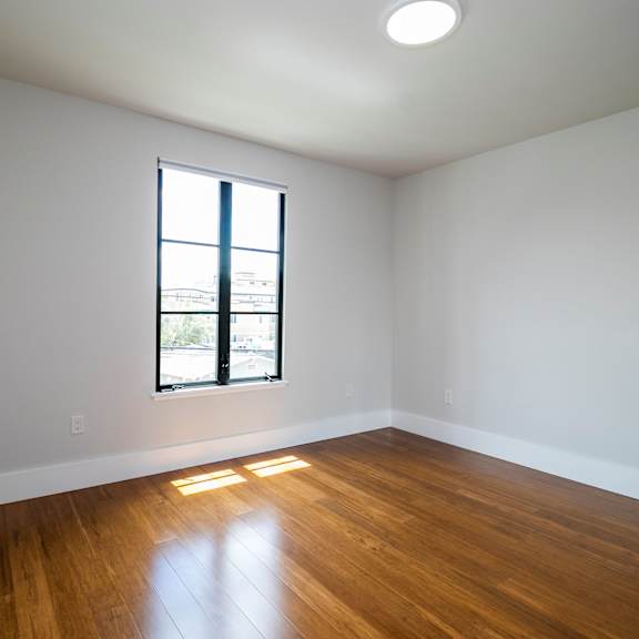 a room with a window and wooden floors.