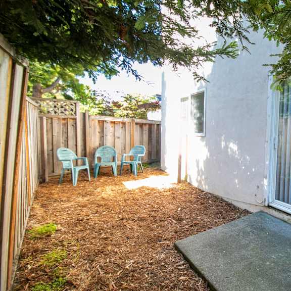a patio with a white wall and a white fence.