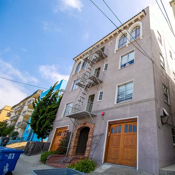 a building with a brown door and a fire escape.
