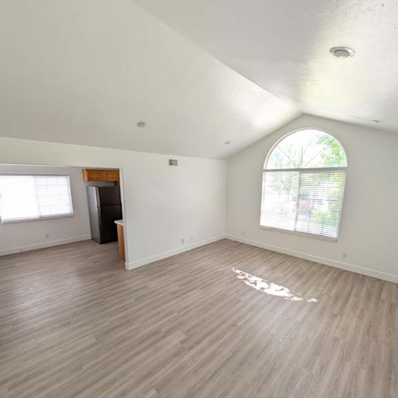 a room with wooden flooring and a large window.