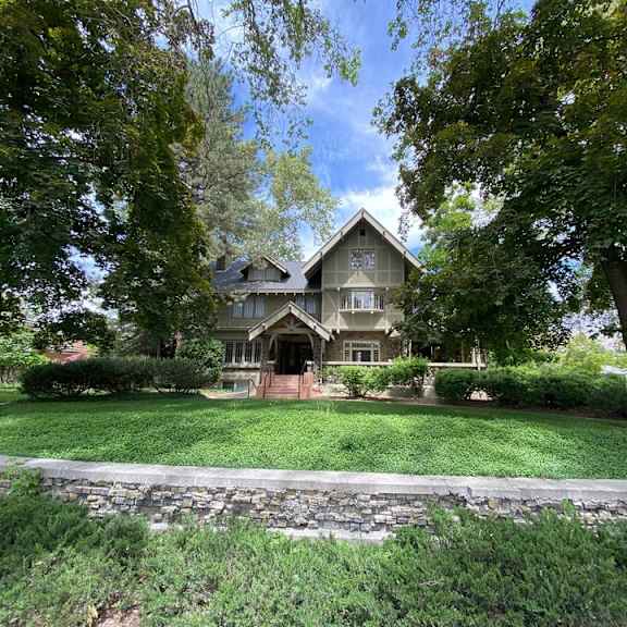 a large house with a stone wall in front of it.