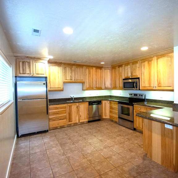 a kitchen with wooden cabinets and a black countertop.