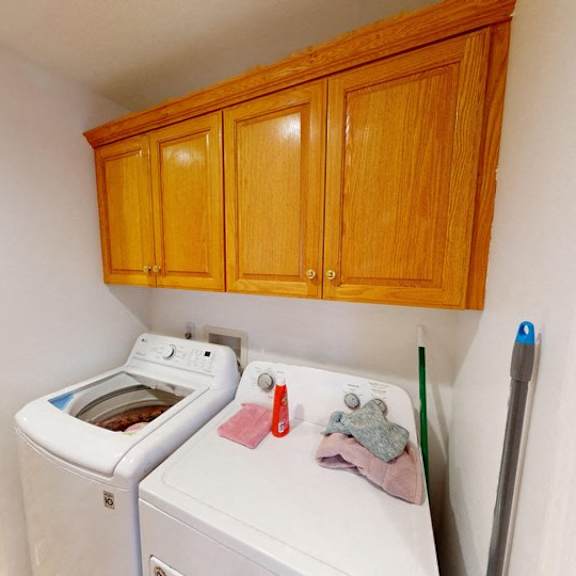 a white washing machine with a red and grey cloth on top of it.